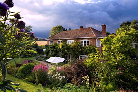 MARINERS_GARDEN__BERKSHIRE_DESIGNER_FENJA_ANDERSON__THE_HOUSE_FROM_THE_UPPER_GARDEN_WITH_STORMY_SKY_