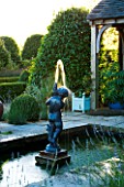 WILKINS PLECK  STAFFORDSHIRE: LAVENDER AND BOX BALLS AROUND A FORMAL RECTANGULAR POOL WITH STATUE OF BOY AND FOUNTAIN
