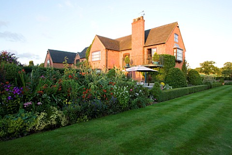 WILKINS_PLECK__STAFFORDSHIRE_VIEW_FROM_THE_MAIN_LAWN_TO_THE_HOUSE_WITH_A_BIG_HERBACEOUS_BORDER