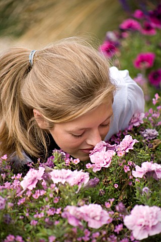 GIRL_AGED_15_SMELLING_FLOWERS_IN_A_CONTAINER_HAZEL_NICHOLS