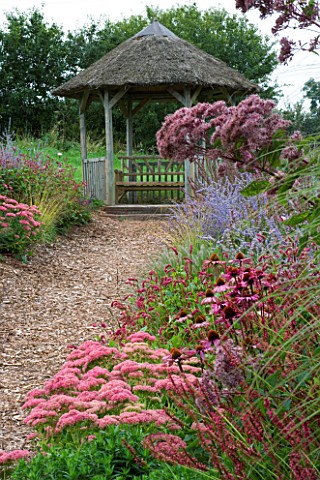 LADY_FARM__SOMERSET_DESIGNER__JUDY_PEARCE__NEW_PERENNIAL_BORDER_VIEW_TO_THATCHED_SEAT_WITH_PEROVSKIA