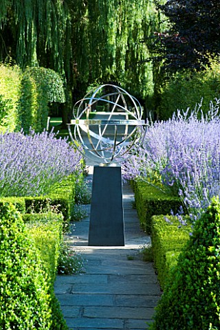 DAVID_HARBER_SUNDIALS_STONE_PATH_WITH_ARMILLARY_SPHERE_SUNDIAL_ON_PLINTH_IN_FORMAL_GARDEN_SURROUNDED