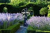 DAVID HARBER SUNDIALS: STAINLESS STEEL ARMILLARY SPHERE SUNDIAL IN FORMAL GARDEN SURROUNDED BY BOX HEDGES AND LAVENDER. EVENING LIGHT
