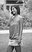 BLACK AND WHITE IMAGE. TEENAGE GIRL (16-17 YEARS) IN A PARK OUTSIDE COLLEGE TALKING ON THE PHONE. TEENAGE GIRLS  ONE TEENAGE GIRL ONLY  STUDENT  COLLEGE  CASUAL CLOTHING