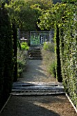 THROUGHAM COURT  GLOUCESTERSHIRE. DESIGNER: CHRISTINE FACER: VIEW ALONG YEW HEDGES TO SLATE STARBURST BLACK REFLECTIVE POOL AND RILL AND CHAOS GATE
