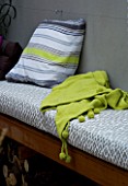 DESIGNER - CHARLOTTE ROWE  LONDON: CHARLOTTE ROWES OWN GARDEN AT NIGHT - WESTERN RED CEDAR SEAT WITH CUSHIONS AND LIME GREEN THROW