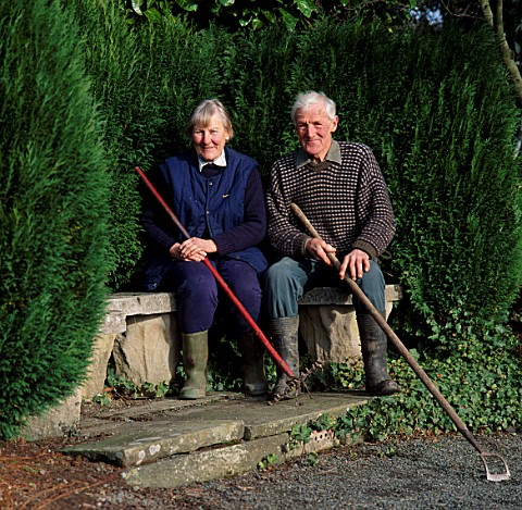 RAY_AND_BARBARA_JOSEPH_SIT_ON_A_BENCH_IN_THEIR_GARDEN_AT_THE_DINGLE__WALES