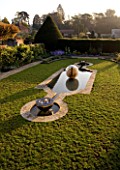 DAVID HARBER SUNDIALS: CHALICE WATER FEATURE AND ETHER WATER FEATURE IN A POOL IN EARLY MORNING DAWN LIGHT. CHAMOMILE LAWN