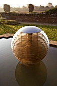 DAVID HARBER SUNDIALS: ETHER WATER FEATURE IN A POOL IN EARLY MORNING DAWN LIGHT. CHAMOMILE LAWN