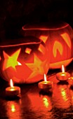 HALLOWEEN: STILL LIFE ON SIDEBOARD AT NIGHT WITH GOLD CANDLES AND PUMPKINS
