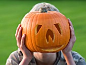 HALLOWEEN: BOY (AGED 13) WITH PUMPKIN IN FRONT OF FACE