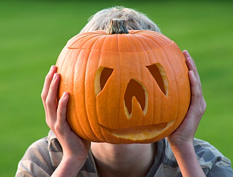 HALLOWEEN_BOY_AGED_13_WITH_PUMPKIN_IN_FRONT_OF_FACE