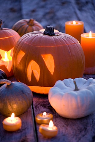 HALLOWEEN_STILL_LIFE_ON_WOODEN_TABLE_AT_NIGHT_WITH_CANDLES__PUMPKINS__SQUASHES_AND_GOURDS