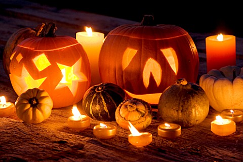 HALLOWEEN_STILL_LIFE_ON_WOODEN_TABLE_AT_NIGHT_WITH_CANDLES__PUMPKINS__GOURDS_AND_SQUASHES