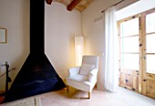 SON BERNADINET HOTEL  NEAR CAMPOS  MALLORCA : THE LIVING ROOM WITH WHITE CHAIR AND BLACK FIRE