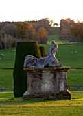 CASTLE HILL  DEVON: STATUE ON PEDESTAL ON THE TERRACES WITH VIEW TO THE TRIUMPHAL ARCH IN AUTUMN. EVENING LIGHT