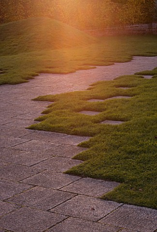 MARKS_HALL__ESSEX__EARLY_EVENING_LIGHT_SPILLS_ONTO_A_STONE_PATH_IN_THE_WALLED_GARDEN_WITH_THE_EARTH_