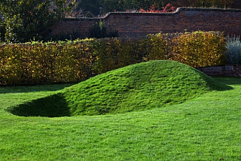 MARKS_HALL__ESSEX__THE_EARTH_SCULPTURE_IN_THE_WALLED_GARDEN_WITH_A_HORNBEAM_HEDGE_BEHIND