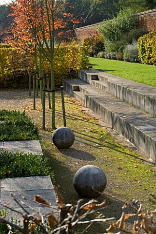 MARKS_HALL__ESSEX__THE_GARDEN_OF_SPHERES_IN_THE_WALLED_GARDEN_STONE_BALLS__STONE_STEPS_AND_AMELANCHI