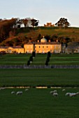 CASTLE HILL  DEVON: VIEW OF THE PALLADIAN HOUSE SEEN ACROSS THE RIVER WITH SHEEP GRAZING IN THE FOREGROUND