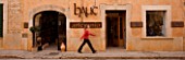 SUITE.DO. GIRL WALKING PAST A SHOP IN SANTANYI  MALLORCA  SPAIN
