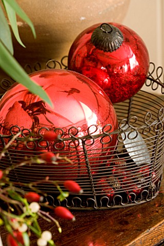 BOONSHILL_FARM_AT_CHRISTMAS_DECORATIVE_RED_CHRISTMAS_TREE_BAUBLES_IN_A_WIRE_BASKET_DESIGNER_LISETTE_