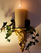 BOONSHILL FARM AT CHRISTMAS: THE DINING ROOM - LIGHTING - WALL CANDLE WRAPPED WITH IVY. DESIGNER: LISETTE PLEASANCE