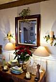 BOONSHILL FARM AT CHRISTMAS: THE DINING ROOM - LIGHTING - WALL CANDLES WRAPPED WITH IVY  MIRROR WITH MISTLETOE  SIDEBOARD WITH POINSETTIA IN SILVER CONTAINER