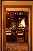 BOONSHILL FARM AT CHRISTMAS: THE DINING ROOM - TABLE WITH CHAIRS AND FIRE IN BACKGROUND. DESIGNER: LISETTE PLEASANCE