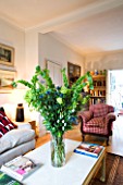 CHARLOTTE ROWES HOUSE - INTERIOR SHOT OF LIVING ROOM WITH SETTEE  TABLE WITH GREEN FLORAL DISPLAY