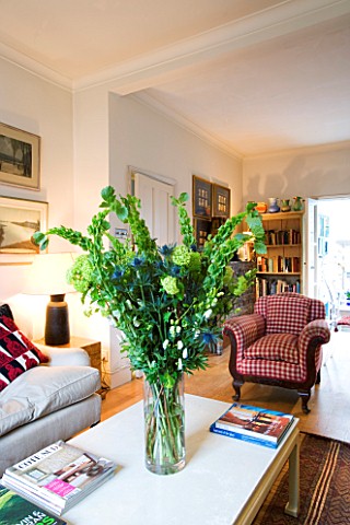 CHARLOTTE_ROWES_HOUSE__INTERIOR_SHOT_OF_LIVING_ROOM_WITH_SETTEE__TABLE_WITH_GREEN_FLORAL_DISPLAY