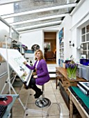 CHARLOTTE ROWES HOUSE - INTERIOR SHOT OF CHARLOTTE IN HER DESIGN OFFICE WORKING ON A GARDEN DESIGN