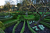 CERNEY HOUSE  GLOUCESTERSHIRE: FORMAL PARTERRE IN THE WALLED GARDEN WITH FRUIT TREES  SNOWDROPS AND A SUNDIAL