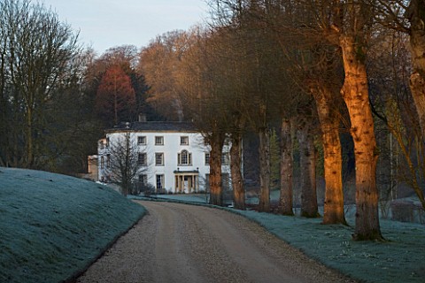 CERNEY_HOUSE_GARDEN__GLOUCESTERSHIRE_VIEW_ALONG_THE_DRIVE_TO_THE_HOUSE_IN_WINTER