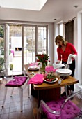 DESIGNER: CHARLOTTE ROWE  LONDON: CHARLOTTE LAYING THE TABLE IN THE DINING ROOM