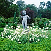 CUPID SURROUNDED BY WHITE ARGYRANTHEMUM IN THE WHITE GARDEN AT CHENIES MANOR  BUCKINGHAMSHIRE