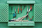 PROVENCE  FRANCE - ALTAVES. GARDENING TOOLS HANGING FROM GREEN PAINTED SHELF IN VEGETABLE GARDEN