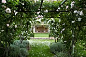PRIVATE GARDEN  PROVENCE  FRANCE - DESIGNER DOMINIQUE LAFOURCADE. WOODEN PERGOLA WITH CLIMBING WHITE ROSE ICEBERG AND VIEW TO SEATING AREA