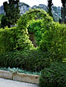 PRIVATE GARDEN  PROVENCE  FRANCE - DESIGNER DOMINIQUE LAFOURCADE. ARCH WITH SOLANUM JASMINOIDES WITH PROSTRATE ROSEMARY BELOW AND STACHYS IN STONE TROUGHS