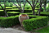 PRIVATE GARDEN  PROVENCE  FRANCE - DESIGNER DOMINIQUE LAFOURCADE. LOW HEDGE OF CLIPPED BOX WITH DECORATIVE URN