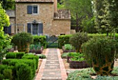 PRIVATE GARDEN PROVENCE  FRANCE - DESIGNER DOMINIQUE LAFOURCADE. PATH IN POTAGER WITH ROSEMARY RAISED BEDS WITH VEGETABLES-CARROTS AND ONIONS AND CONTAINERS WITH PROSTRATE ROSEMARY