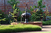 THE WALLED GARDEN AT COWDRAY  WEST SUSSEX. DESIGNER: JAN HOWARD - RAISED BRICK POOL/POND WITH METAL FOUNTAIN AND LAVENDER