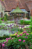 THE WALLED GARDEN AT COWDRAY  WEST SUSSEX. DESIGNER: JAN HOWARD - METAL GAZEBO WITH SEAT SURROUNDED BY BOX EDGED BEDS WITH ALLIUM PURPLE SENSATION  NEPETA AND PEONIES