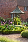 THE WALLED GARDEN AT COWDRAY  WEST SUSSEX. DESIGNER: JAN HOWARD - METAL GAZEBO WITH BOX EDGED BEDS WITH ALLIUM PURPLE SENSATION