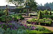 THE WALLED GARDEN AT COWDRAY  WEST SUSSEX. DESIGNER: JAN HOWARD - METAL GAZEBO WITH SEAT SURROUNDED BY BOX EDGED BEDS WITH ALLIUM PURPLE SENSATION AND NEPETA