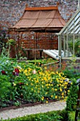 THE WALLED GARDEN AT COWDRAY  WEST SUSSEX. DESIGNER: JAN HOWARD - METAL GAZEBO BEHIND YELLOW AND RED BORDER IN EARLY SUMMER