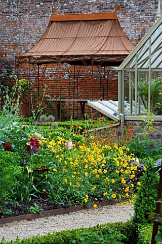 THE_WALLED_GARDEN_AT_COWDRAY__WEST_SUSSEX_DESIGNER_JAN_HOWARD__METAL_GAZEBO_BEHIND_YELLOW_AND_RED_BO