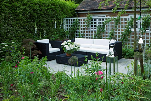 DESCHARLOTTE_ROWE_LONDONSMALL_SECLUDED_COUNTRY_GARDEN_IN_JUNE_WITH_SOFA_ARMCHAIR_TABLE_TRELLIS_DIGIT