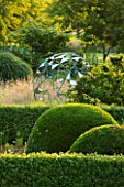 DAVID HARBER SUNDIALS: THE NUAGE - BRONZE SPHERE SCULPTURE SEEN ACROSS THE PARTERRE WITH TOPIARY AT PETTIFERS  OXFORDSHIRE