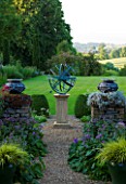 DAVID HARBER SUNDIALS: BRONZE ARMILLARY SPHERE SUNDIAL ON PATH BETWEEN STONE WALLS AND VIEW ACROSS LAWN AT PETTIFERS  OXFORDSHIRE. FORMAL GARDEN